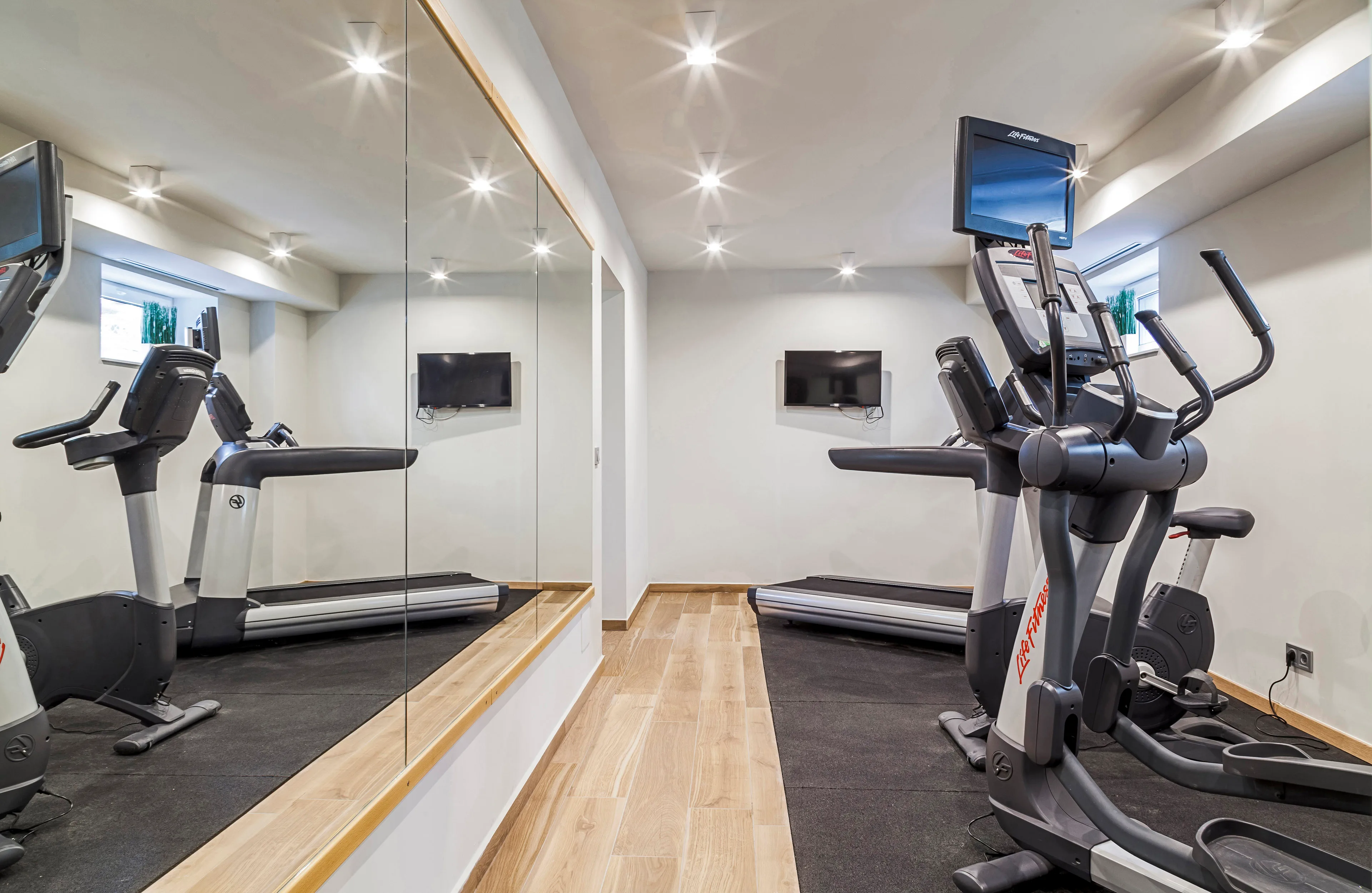 Edzőterem Life Fitness elliptikus géppel, futópaddal és tükörfallal